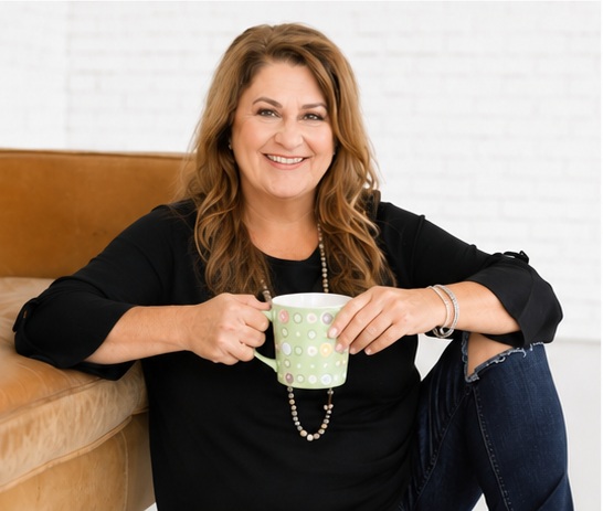 Ann Marie Rogers smiling warmly while holding a cup